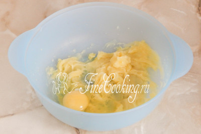 Шаг 3. В другой посуде (в которой будем замешивать тесто для картофельного хлеба) соединяем сырое куриное яйцо и отварной картофель, который предварительно превратим в пюреобразную массу