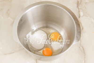 В отдельную посуду разбиваем пару куриных яиц, добавляем 90 граммов сахарного песка и столовую ложку ванильного сахара 