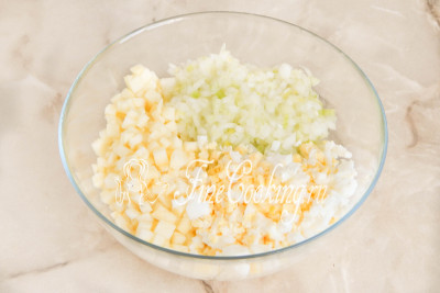 В подходящей по объему посуде соединяем куриные яйца, яблочные кубики (сок лимона сливаем) и маринованный лук (отжимаем от маринада)