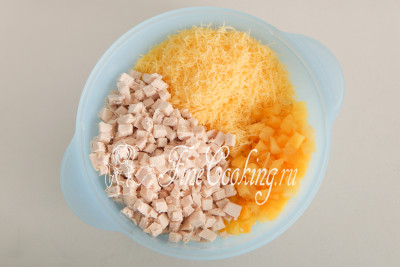 Соединяем подготовленные ингредиенты для салата: кладем в большую миску остывшую вареную курицу, консервированные ананасы и тертый сыр