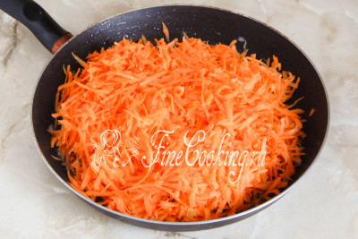 Подливаем в сковороду еще 50 миллилитров масла, прогреваем его и выкладываем измельченную морковь