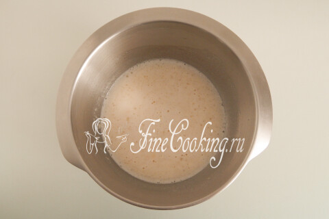 Тёплая сыворотка с сахаром, солью и маслом в ёмкости для замеса