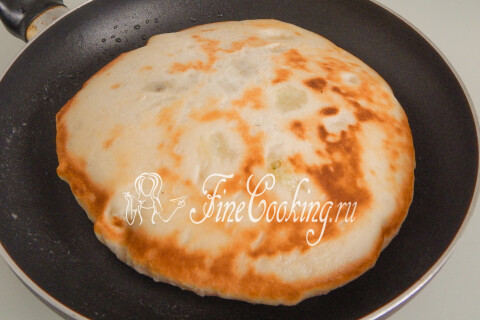 Надувшаяся при жарке лепёшка, перекладываемая на тарелку