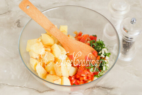 Обжаренный картофель с овощной зажаркой, чесноком и зеленью в миске.