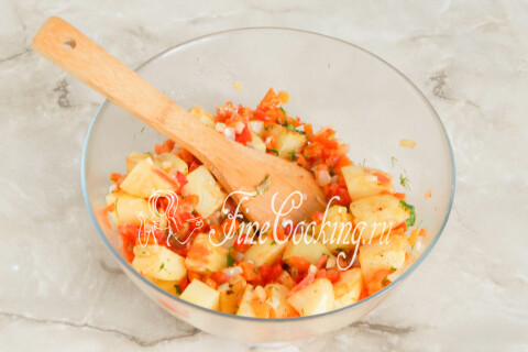Смесь картофеля с овощами, перемешанная в глубокой миске.