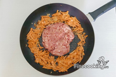 Мясной фарш в сковороде, его разбивают лопаткой во время приготовления.