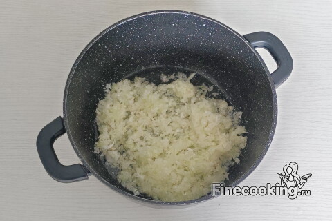 Лук в кастрюле с маслом, тушится на среднем огне, кусочки становятся прозрачными.