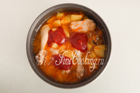 Томатный соус, добавленный в чашу с курицей и картофелем.
